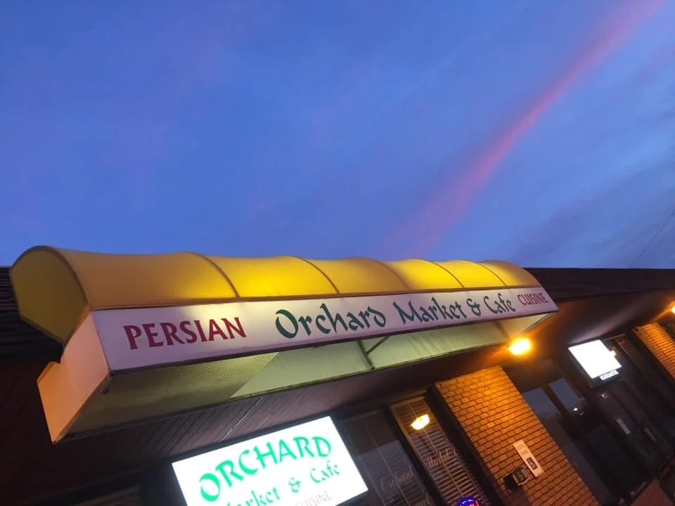 Orchard Market & Cafe storefront with its yellow awning and restaurant signs